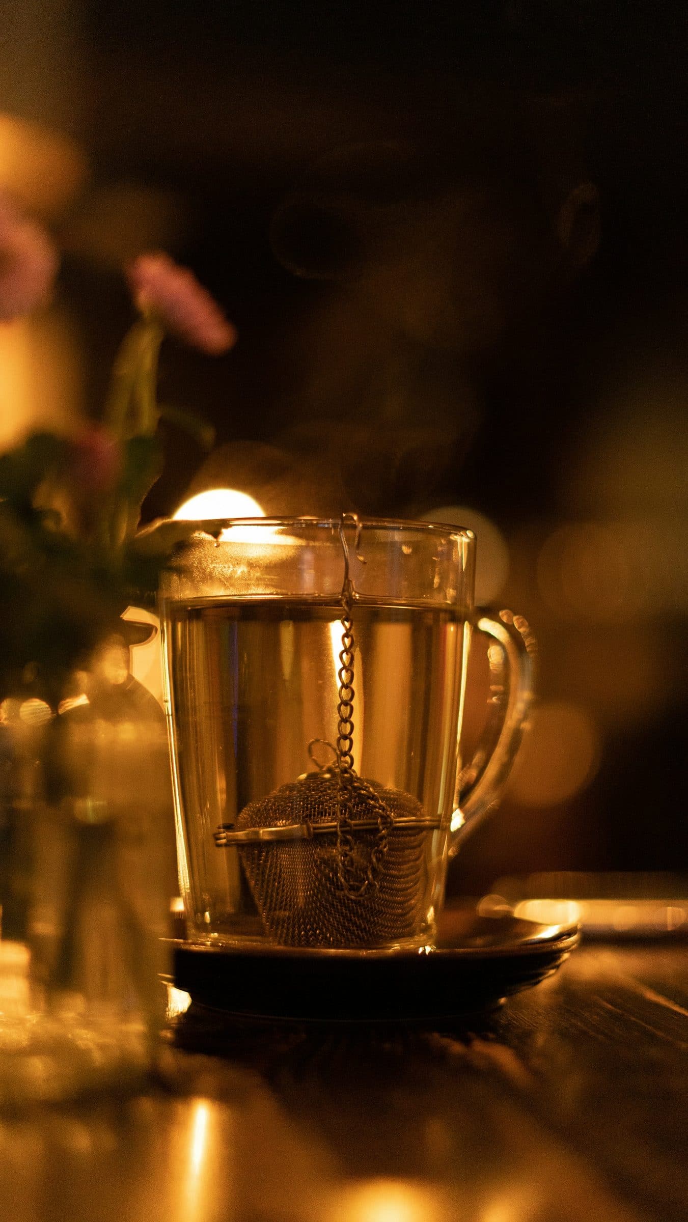 A glass of chai on a table, lit from behind