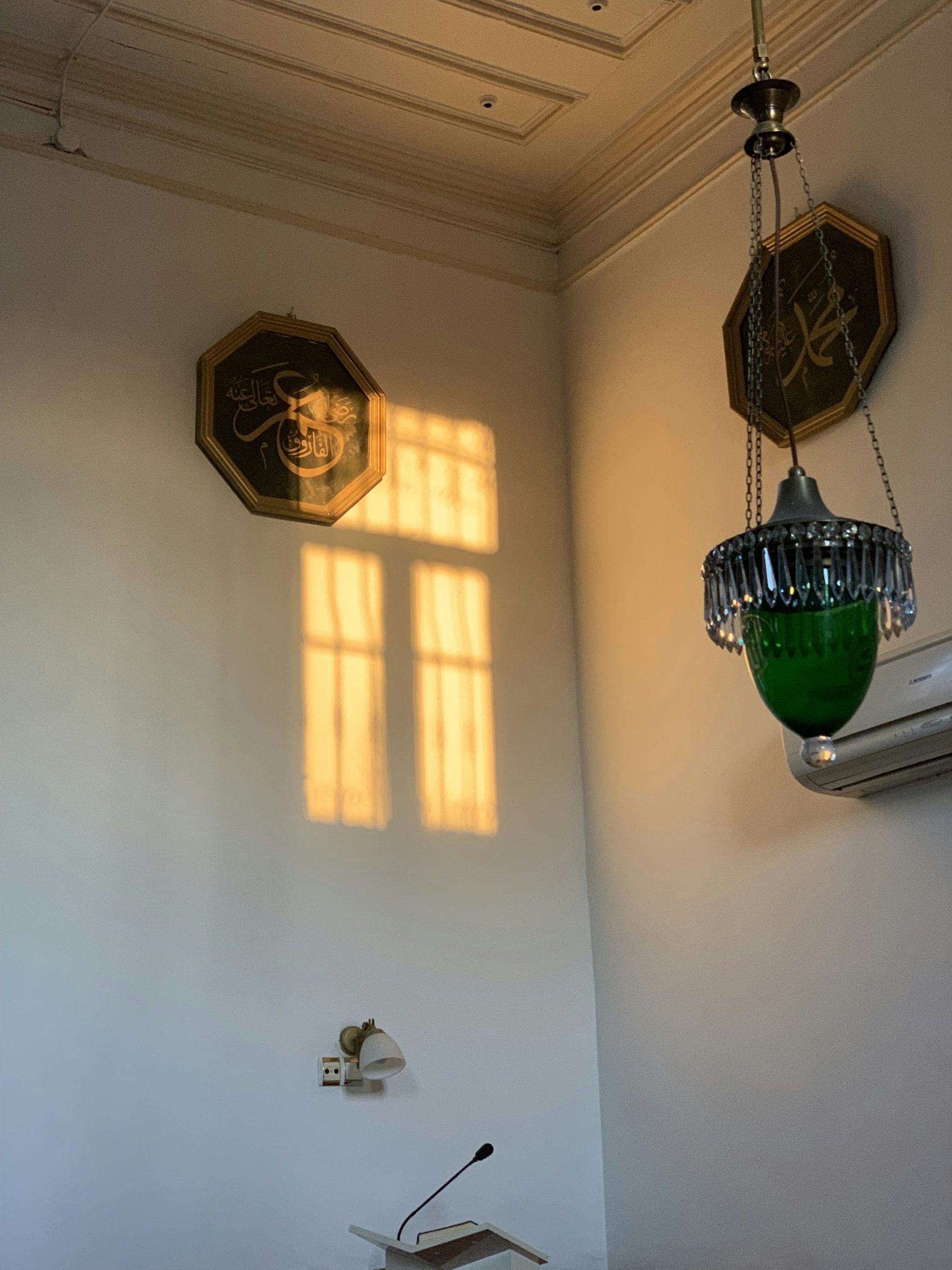 A quiet room with afternoon light coming through a tall shuttered window