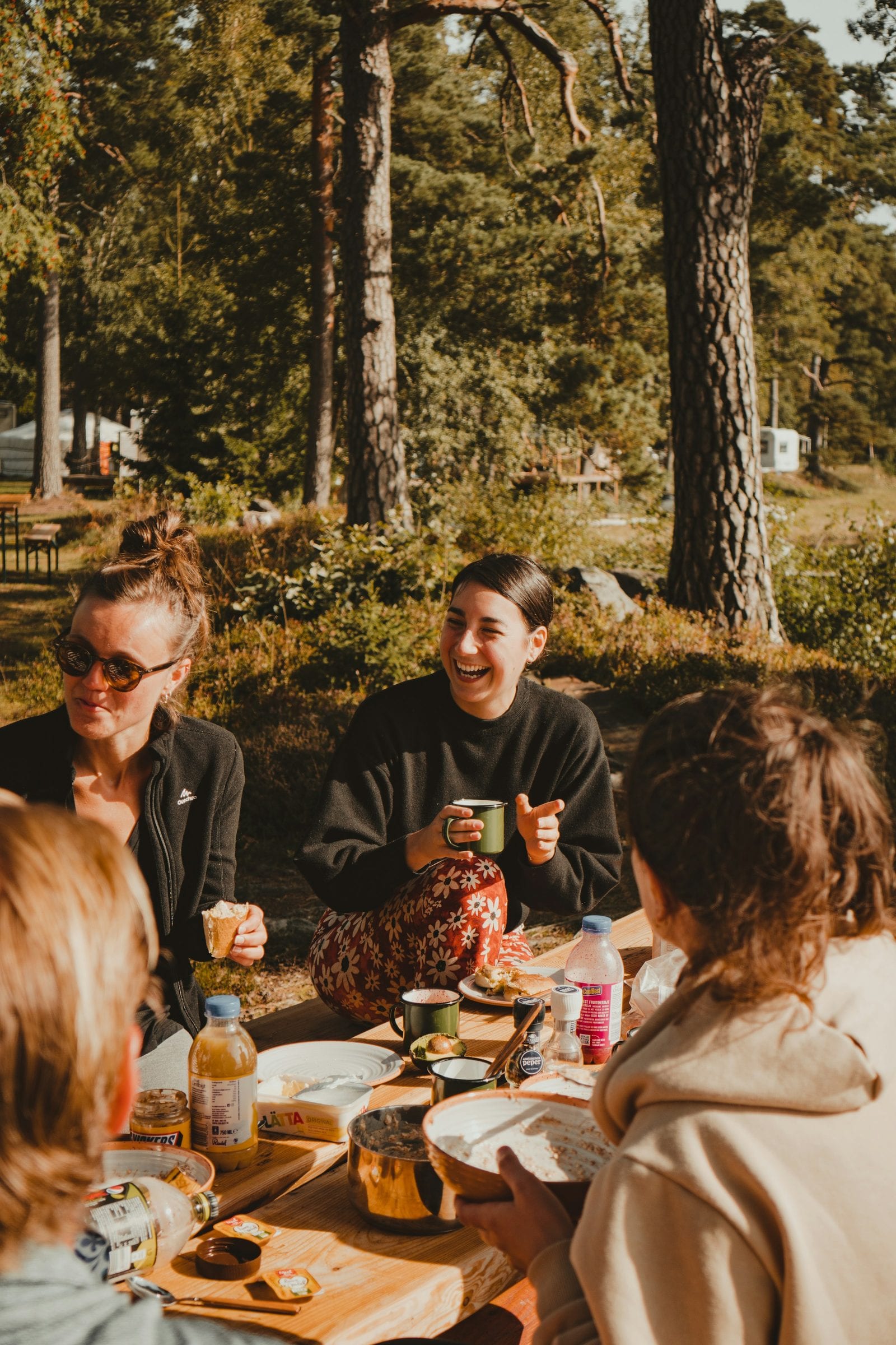 A family sharing a long table outdoors in late afternoon light